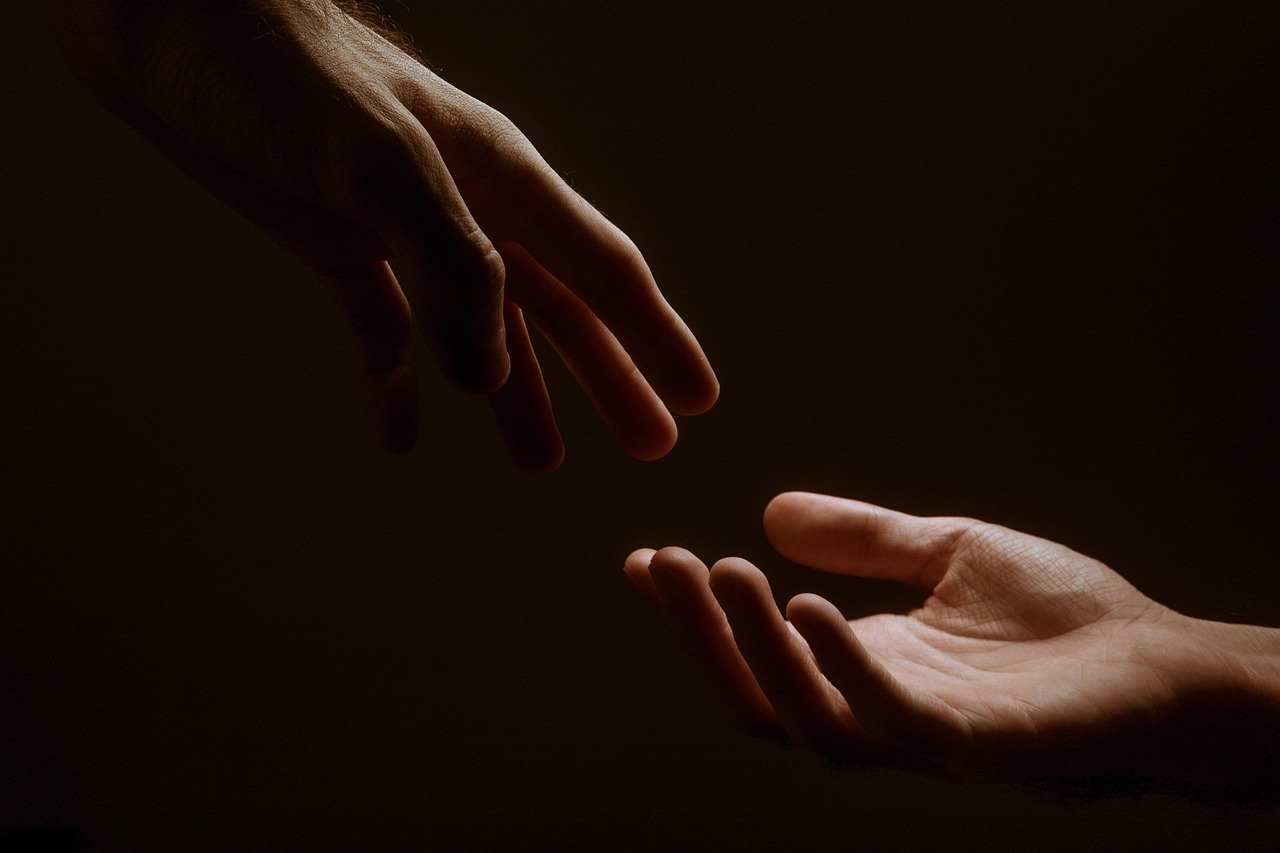 human hand reaching towards glowing holographic interface