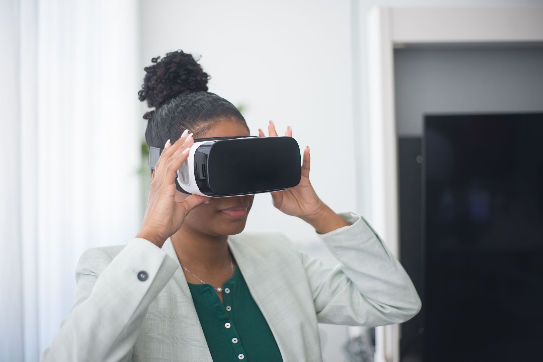 A woman wearing VR glasses indoors, exploring virtual reality in a professional environment.