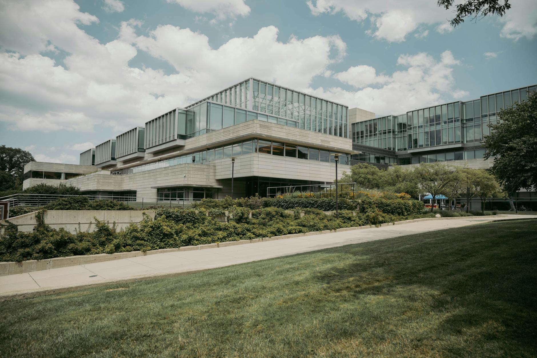 Contemporary glass and concrete university building with lush greenery in Chicago, USA.