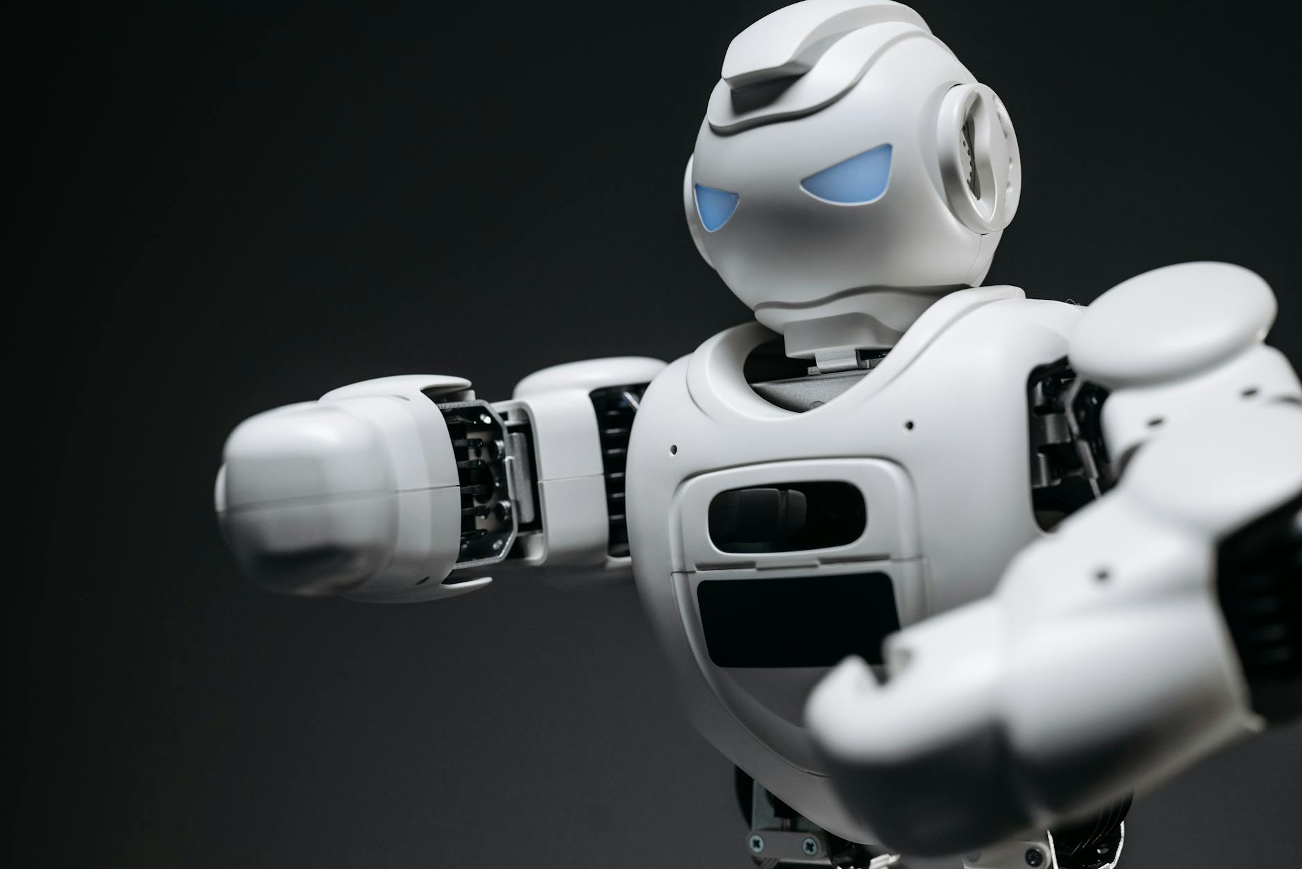 Detailed close-up of a high-tech white robot in a studio setting with a gray background.