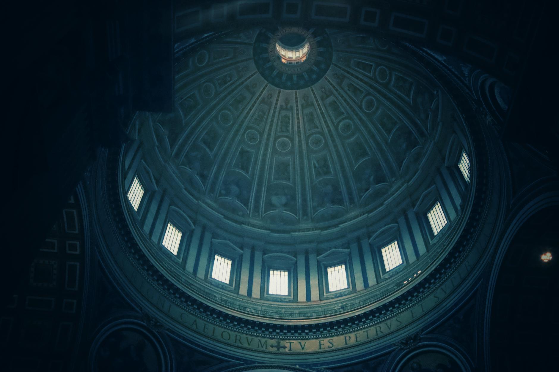 Low angle view of the ornate dome inside St. Peter's Basilica, highlighting its architectural grandeur.