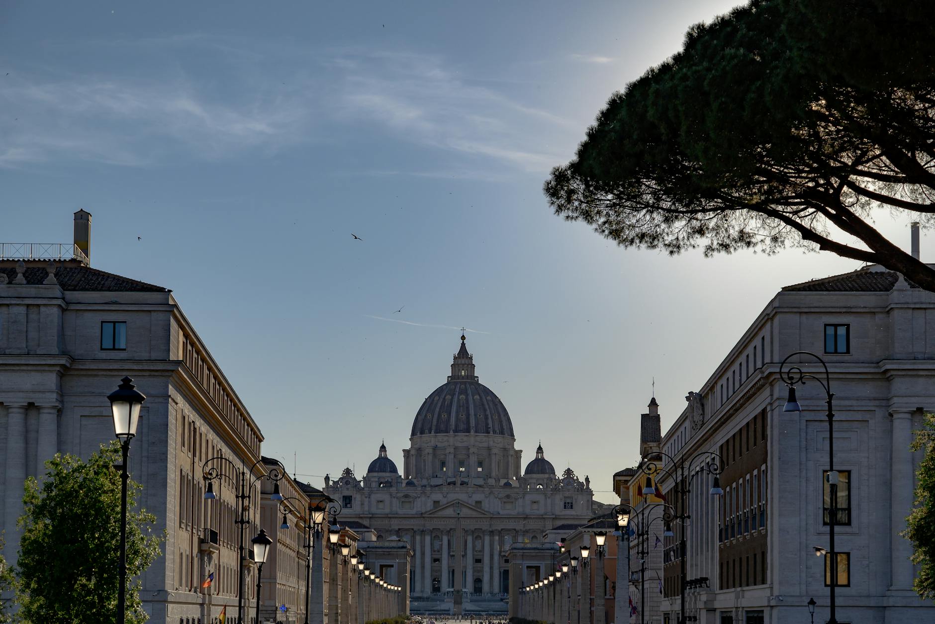 View of St. Peter's Basilica from Via della Conciliazione in Rome during dusk, offering a classic architectural scene.