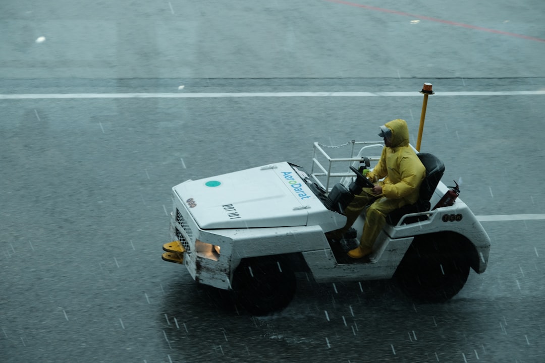 Autonomous agents in action: professional aerial view of self-driving electric vehicle fleet navigating smart city streets at dusk, holographic traffic overlay, human operator monitoring dashboard wit