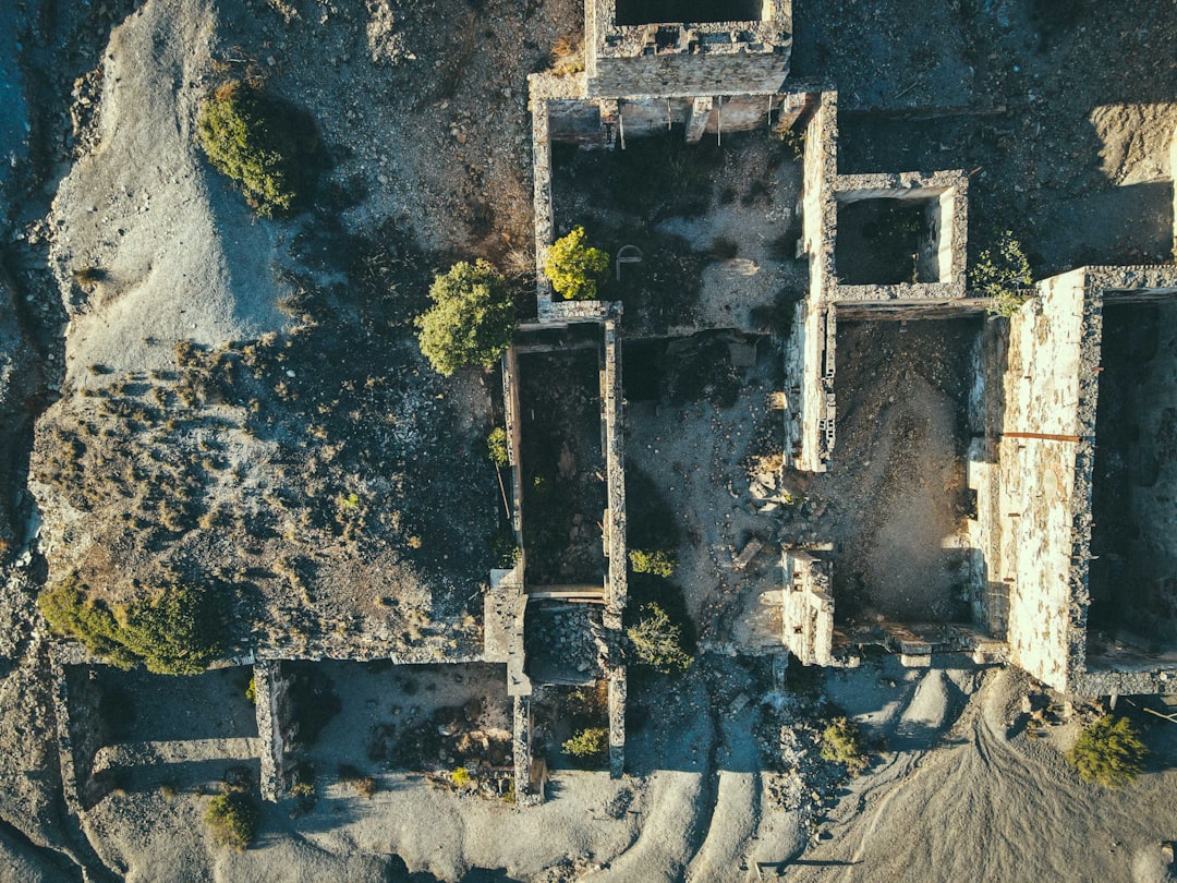 Aerial view of abandoned traditional data center transitioning to decentralized edge computing nodes, sleek solar-powered micro-servers scattered across urban landscape, golden hour lighting, professi