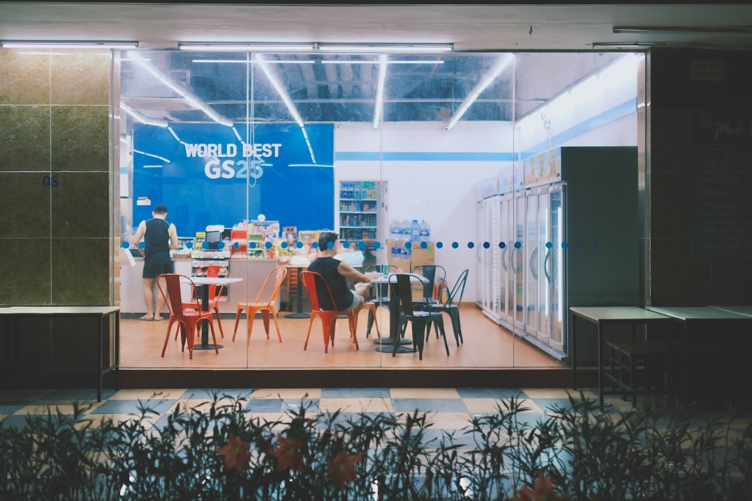Futuristic global education concept, diverse students in sleek glass classroom with holographic AI interface, ambient blue lighting, neural network visualization projected on curved screens, professio