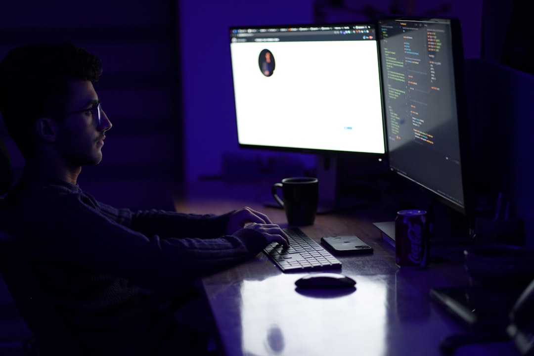 Young professional at minimalist desk with multiple transparent displays, cybersecurity dashboard visible, soft purple ambient glow, upskilling concept, futuristic learning environment