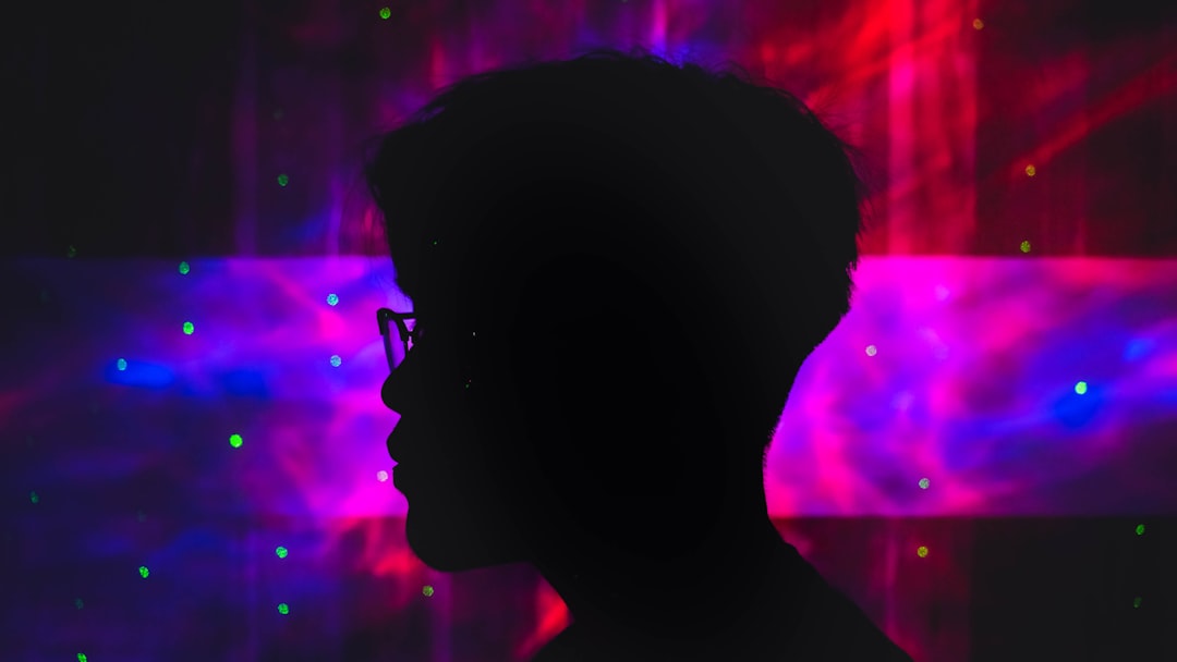 AI ethics concept, silhouetted student face half-lit by glowing screen with algorithmic patterns, dark moody atmosphere, surveillance eye overlay, data privacy visualization, dramatic shadows and cool