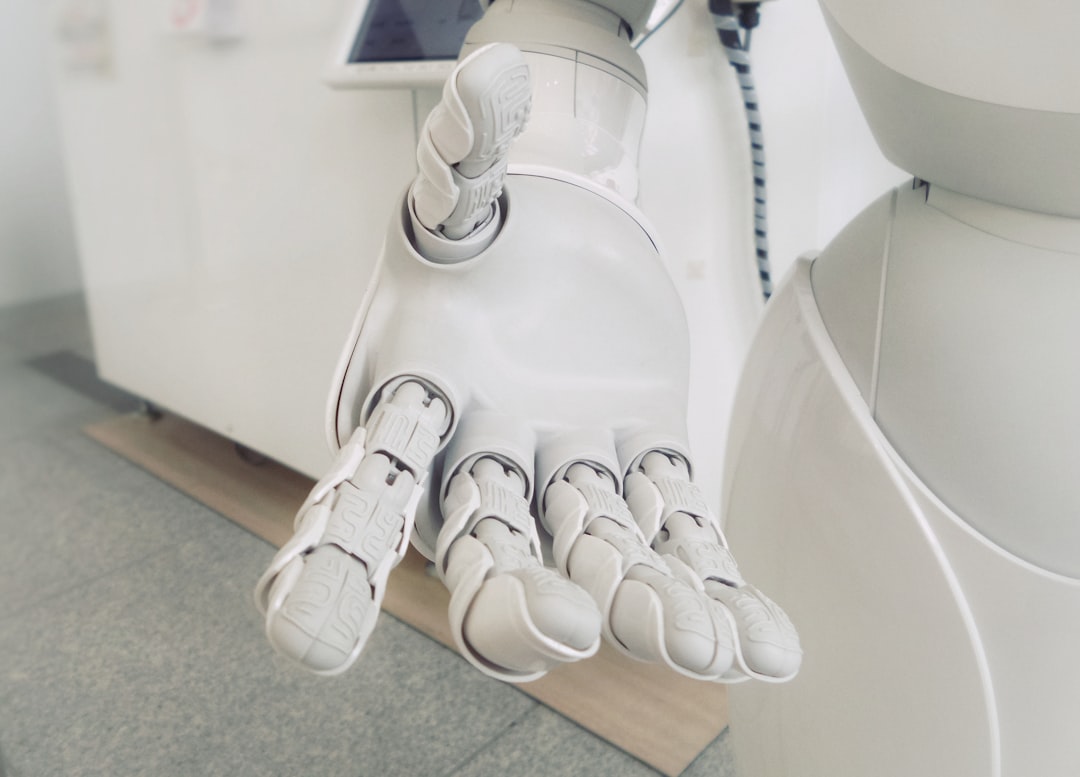 Sleek humanoid robot hand reaching to press glowing autonomous button, clean modern office with floor-to-ceiling glass, holographic data streams, blue and silver palette, human observer blurred in bac
