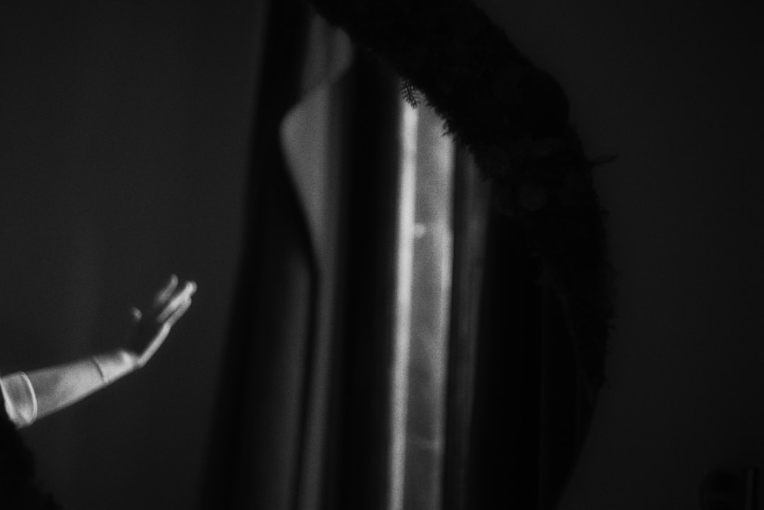 Close-up of robotic arm with microchip detail reaching toward human hand in dramatic lighting, AI ethics concept, server room background with red warning indicators, cinematic tension between autonomy