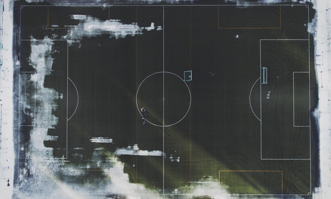 Tactical football analysis with holographic pitch overlay, AI detecting player movement patterns, sleek data dashboard, professional sports analyst, ambient futuristic stadium lighting, clean modern i