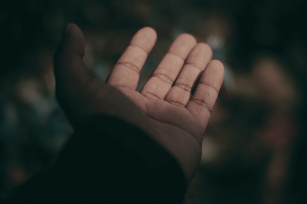 Close-up macro of human hand and robotic hand touching fingertips, microchip detail embedded in robot palm, holographic AI brain visualization between them, clean bokeh background of modern lab, ambie