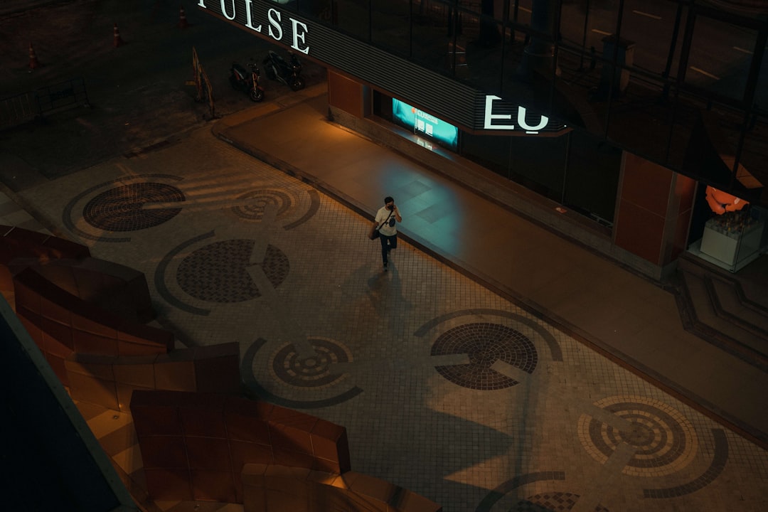 Aerial view of futuristic stock exchange floor with holographic IPO ticker displays, investor shaking hands with AI avatar projection, sleek glass architecture, green and gold ambient lighting, financ
