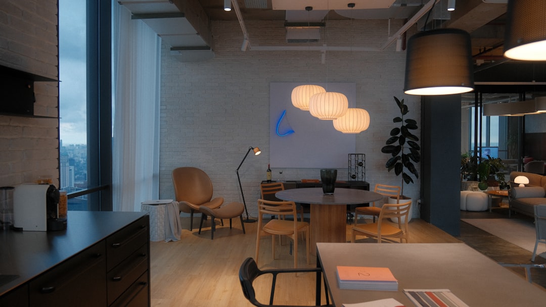 Sleek human-robot collaboration scene in clean modern office, holographic generative AI interface mid-creation, warm ambient lighting, professional designer guiding autonomous agent, futuristic yet ap