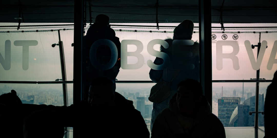 Diverse team of engineers collaborating around holographic AI brain display in minimalist glass office, city skyline visible through windows, warm and cool light contrast, tomorrow's technology today