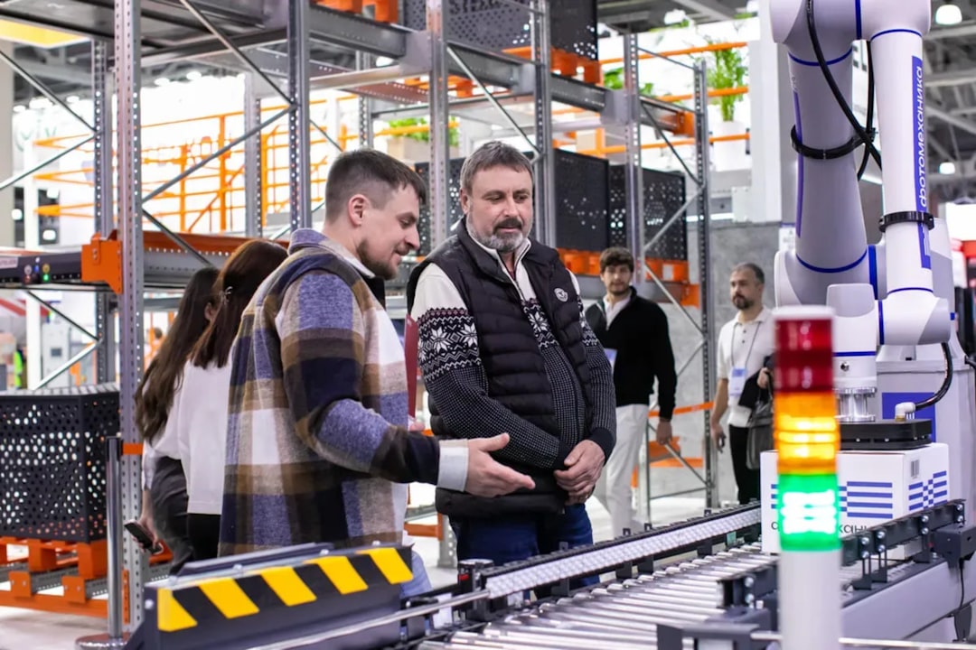 Human-robot collaboration in industrial smart factory, worker with augmented reality glasses examining robotic arm, clean modern manufacturing floor, soft volumetric lighting, Wired magazine documenta
