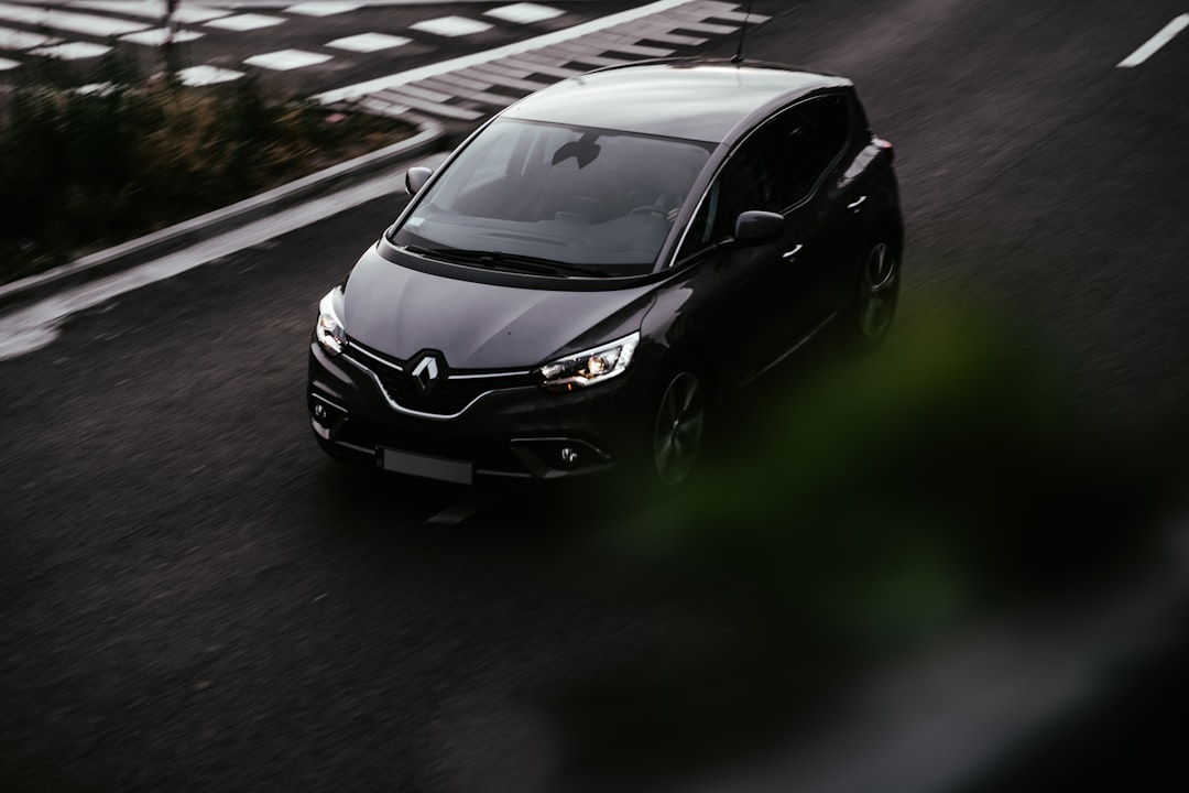 Autonomous Renault vehicle driving through modern city at dusk, empty driver's seat with steering wheel retracted, sensor arrays glowing, cinematic street lighting, editorial tech photography