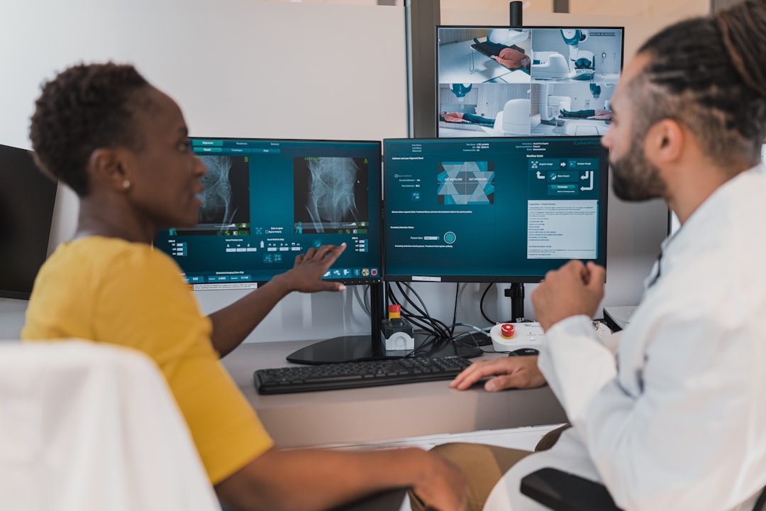 Diverse professionals collaborating with holographic AI interfaces in clean modern office, medical AI and robotics screens visible, warm and cool mixed lighting, human-technology integration