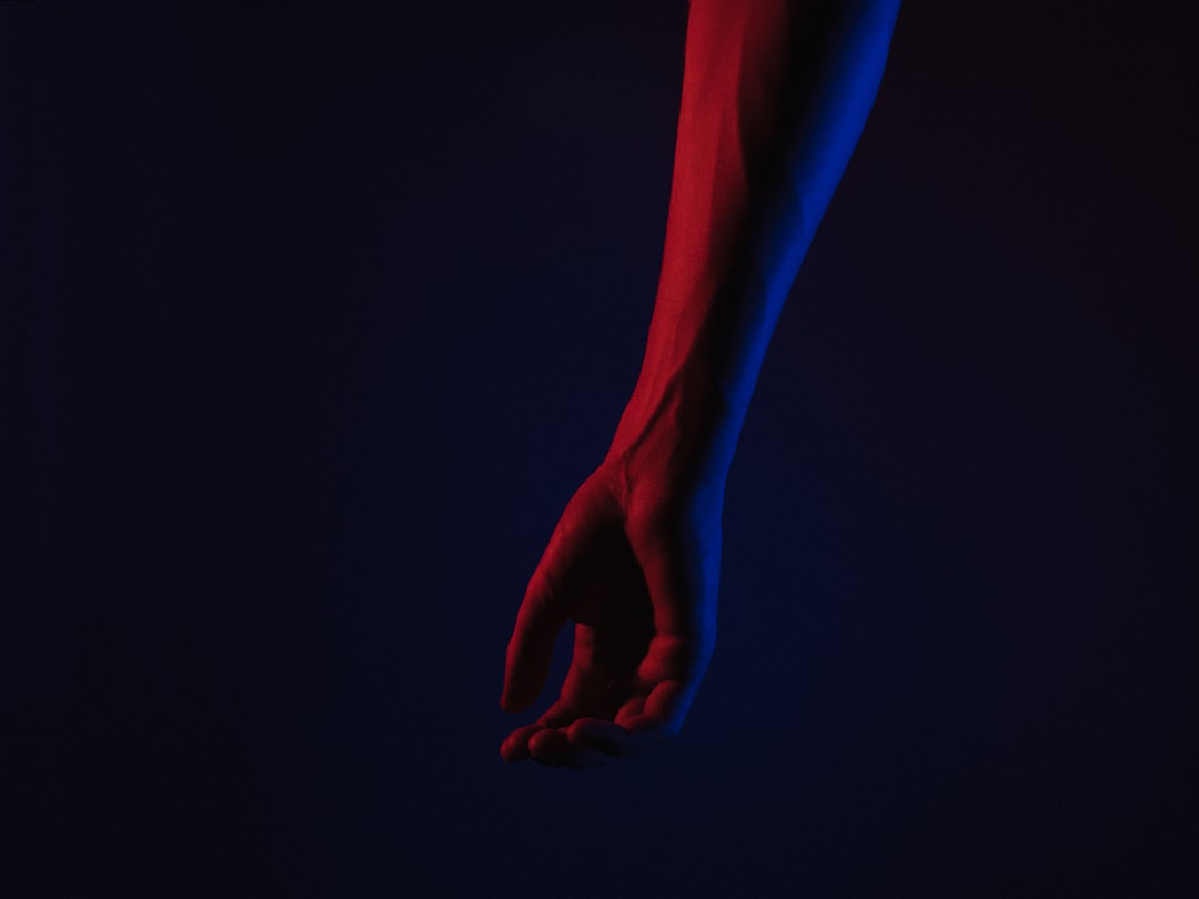 Human hand and robotic arm reaching toward balanced scales, neural network visualization overlay, dark background with blue ambient glow, AI ethics concept