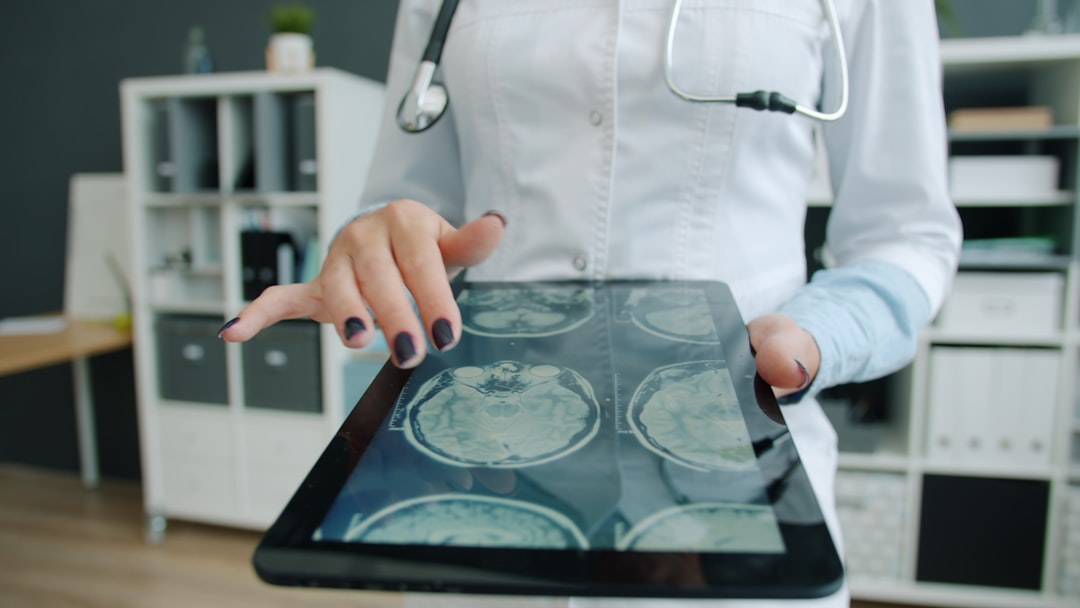 Medical AI concept with doctor analyzing predictive data dashboard, holographic patient metrics floating above tablet, blue-green ambient lighting, professional healthcare technology setting