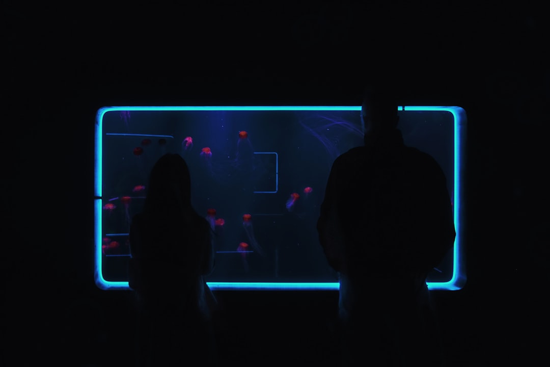 Young diverse professionals staring worriedly at holographic data visualization of declining trust metrics in sleek dark futuristic office with blue ambient lighting