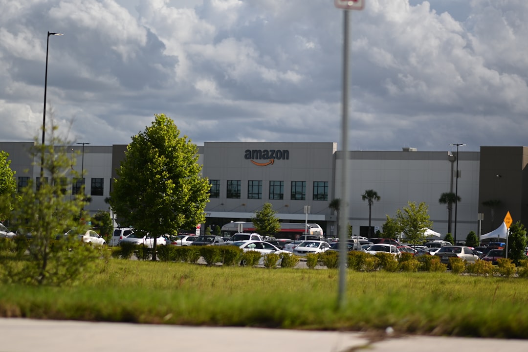 Amazon logistics warehouse with robotic arms sorting packages, glowing orange and blue LED accents, aerial perspective showing AI-driven automation, clean modern industrial design, professional tech p