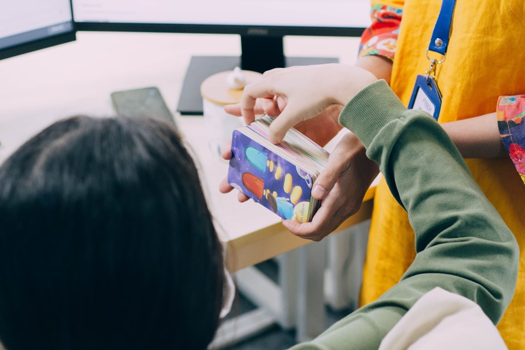 Close-up of diverse child's hands touching holographic adaptive learning interface with colorful data visualizations, warm natural lighting, clean modern educational setting, personalized AI dashboard