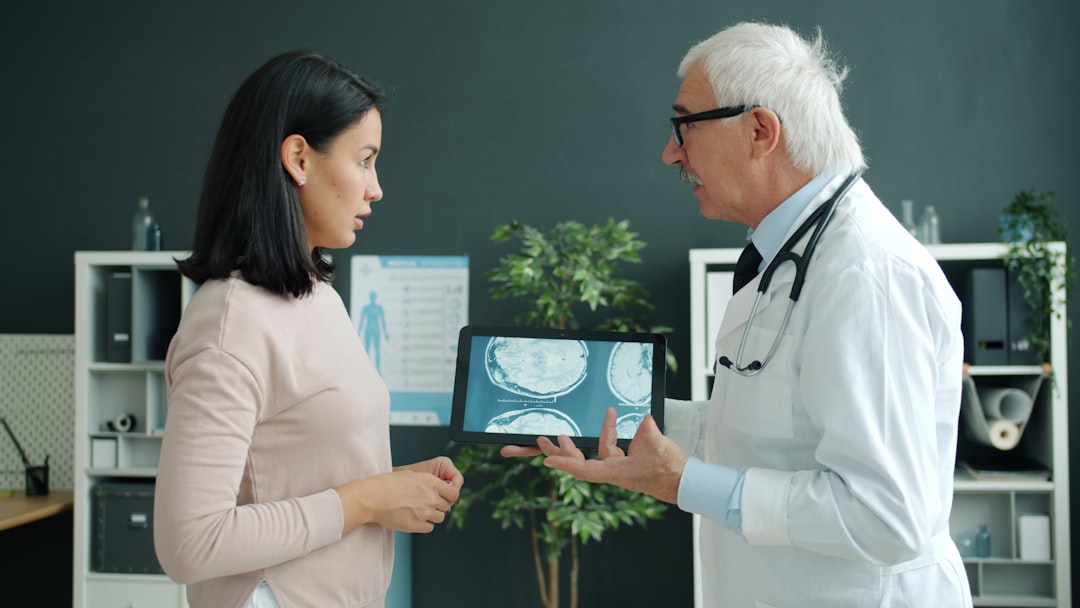 Medical AI professional reviewing holographic patient diagnostics on transparent display in clean modern hospital with soft ambient lighting
