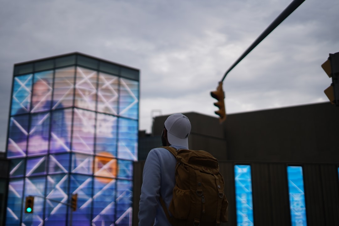 Futuristic university campus at twilight with holographic displays and students using tablets, neural network visualization overlay, sleek ambient lighting, clean modern architecture, human-centered t