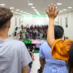 Futuristic Brazilian classroom with holographic displays showing neural network visualizations, diverse students using sleek tablets, ambient blue lighting, clean modern educational setting, professio