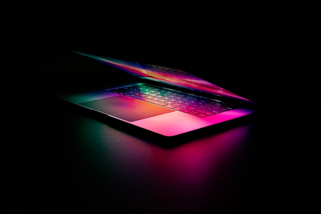 Abstract generative AI artwork emerging from sleek laptop screen, human designer collaborating with holographic creative interface, clean modern office with ambient neon lighting, futuristic digital b