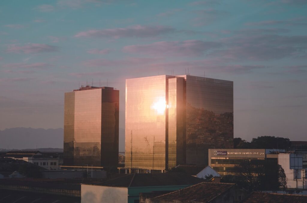 Aerial view of futuristic Brazilian university campus at golden hour with holographic data overlays, modern glass architecture, students walking, ambient teal and amber lighting, regional development