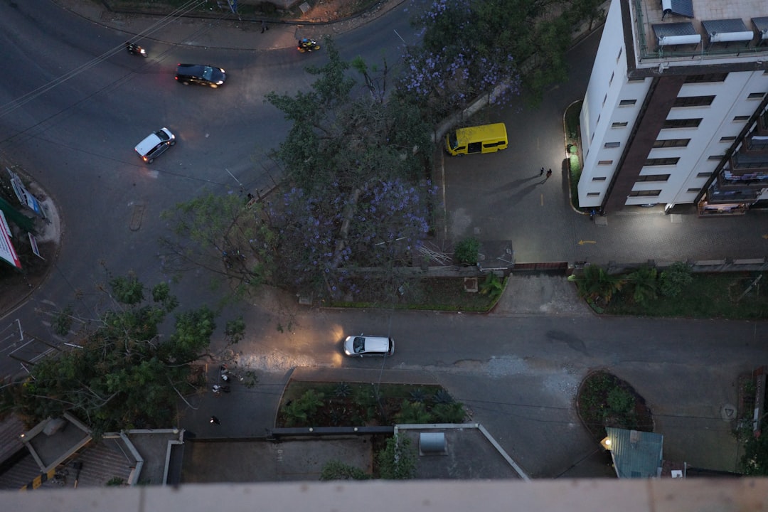 Aerial Kenya, aerial view of intersection with glowing AI traffic optimization overlay, golden hour lighting, seamless human-technology integration, hopeful futuristic cityscape, clean modern infrastr