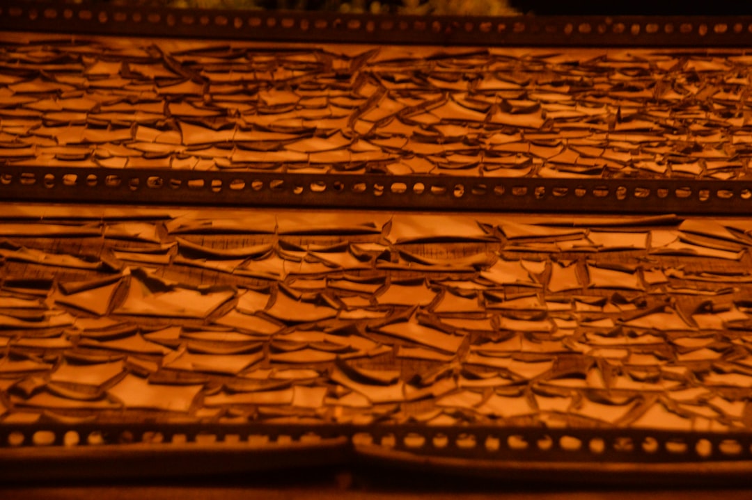 Ancient burned book pages dissolving into golden digital pixels, holographic manuscript floating above sleek glass table, ambient blue lighting, futuristic preservation lab
