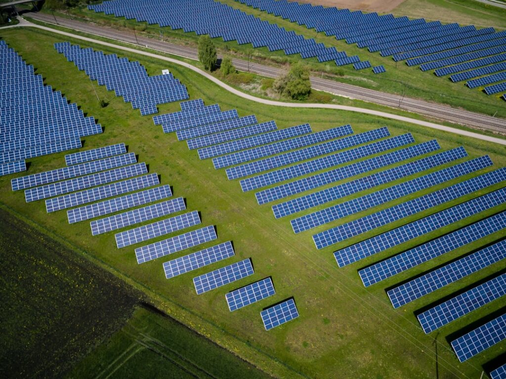 Futuristic aerial view of solar panel fields merging with data center infrastructure, golden hour ambient lighting, professional tech aesthetic, Brazilian flag subtly visible, sleek modern energy tran