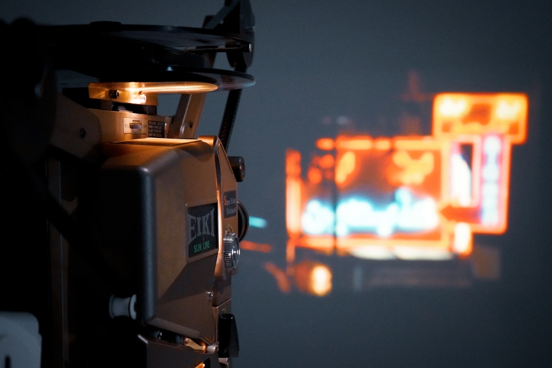 Military drone operator in clean modern control room, holographic battlefield display, professional human-robot collaboration, sleek interface design, dramatic ambient lighting, real-time data visuali
