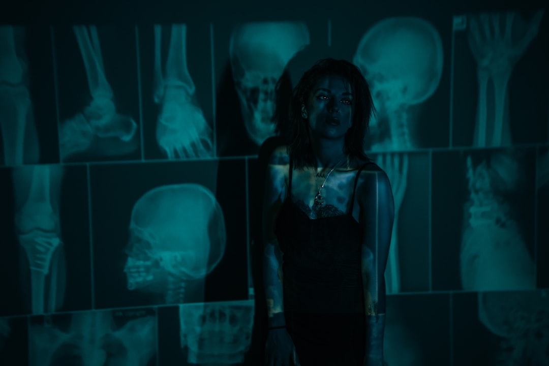 Futuristic medical AI command center with holographic patient data displays, ambient blue lighting, doctor silhouette interacting with neural network visualization, sleek glass surfaces