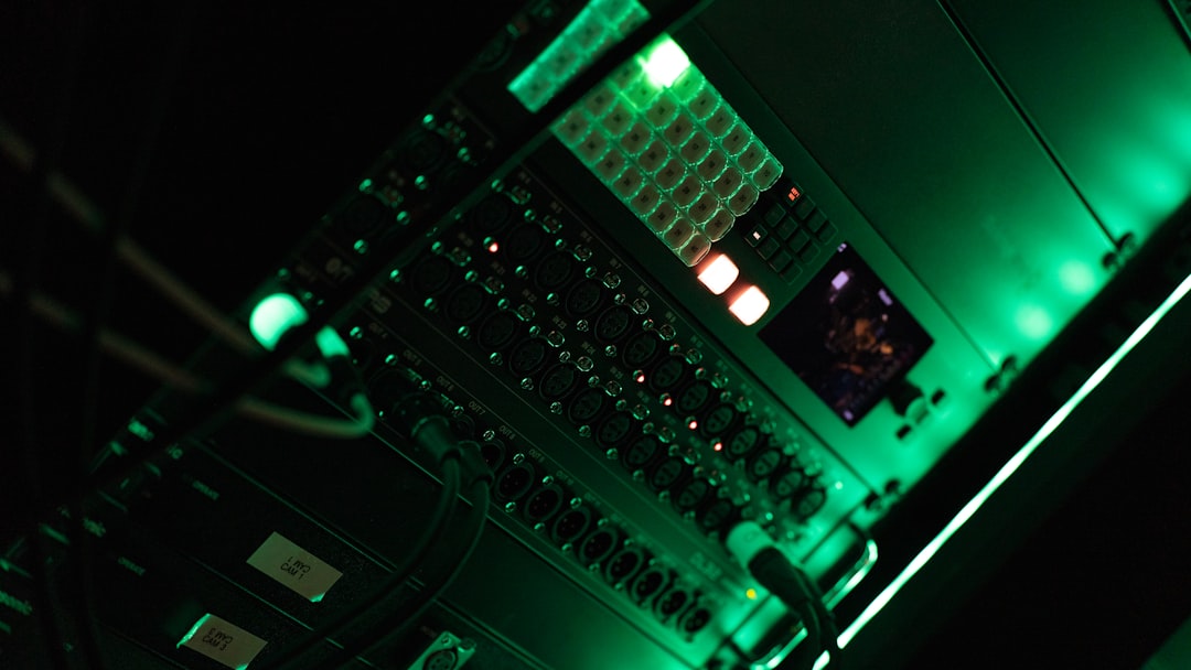 Cybersecurity analyst at multi-screen command center with threat detection dashboards, red alert ambient lighting, server room background, intense professional focus