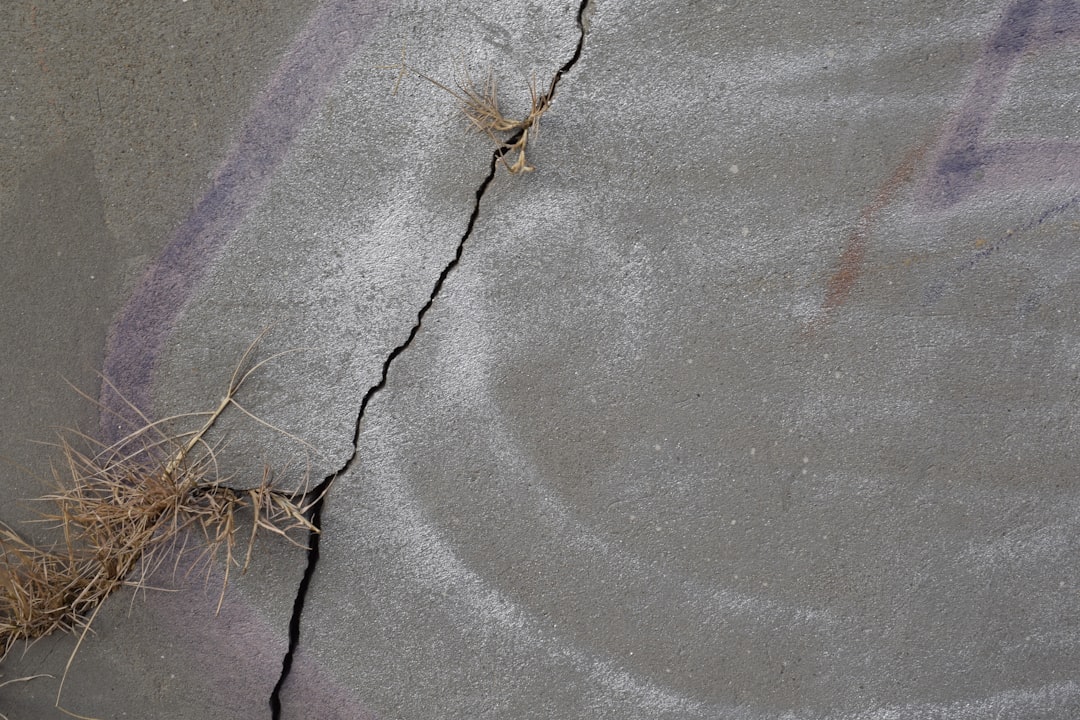 Close-up of microchip detail with fiber optic cables, split composition showing cracked concrete foundation versus polished server room, dramatic contrast lighting, economic tension concept