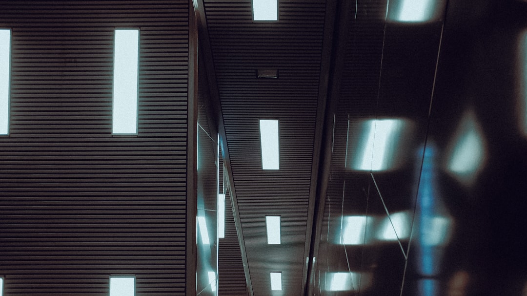 Massive futuristic server room with glowing rows of data center racks, dramatic ambient lighting, engineer in cleanroom suit inspecting hardware, holographic metrics floating, industrial sleek aesthet
