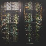 Futuristic data center with holographic neural network visualization, professional engineer monitoring sleek glass screens, ambient blue lighting, clean modern server room infrastructure