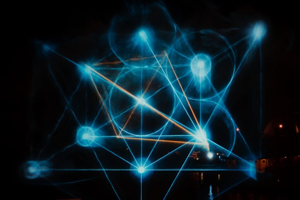 Futuristic holographic display showing interconnected neural network nodes with four glowing pillars, sleek dark data center, ambient blue and purple lighting, professional tech aesthetic, human silho
