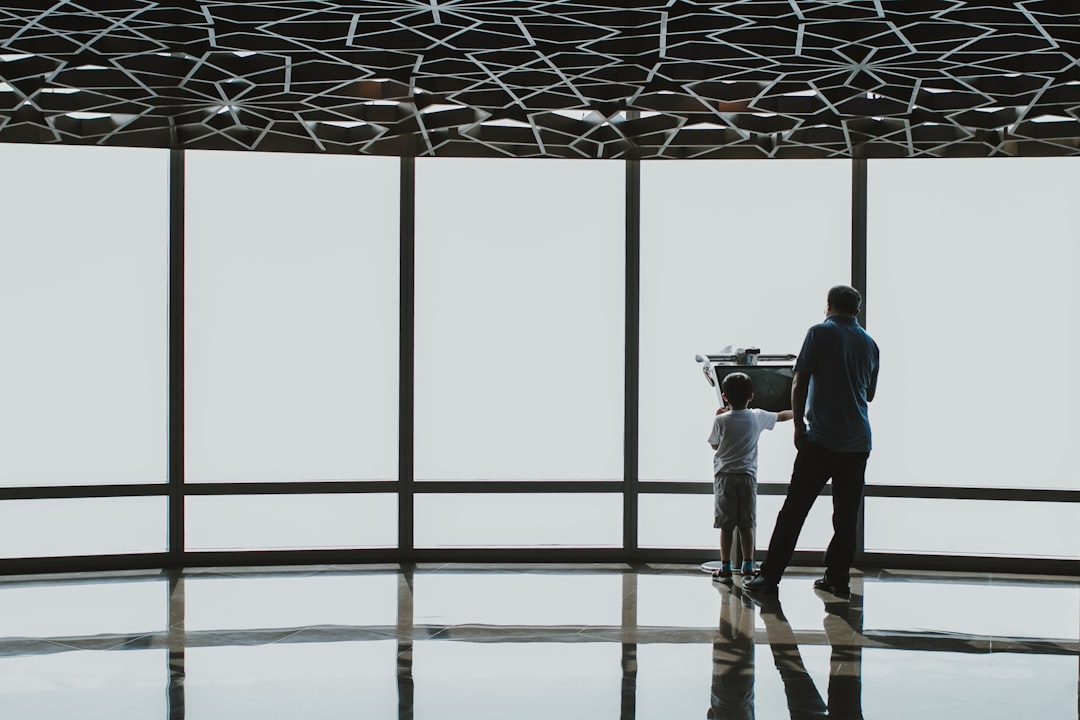 Autonomous AI agent represented as sleek humanoid robot collaborating with professional in clean modern office, holographic workflow diagrams, ambient cyan lighting, abstract neural network connection