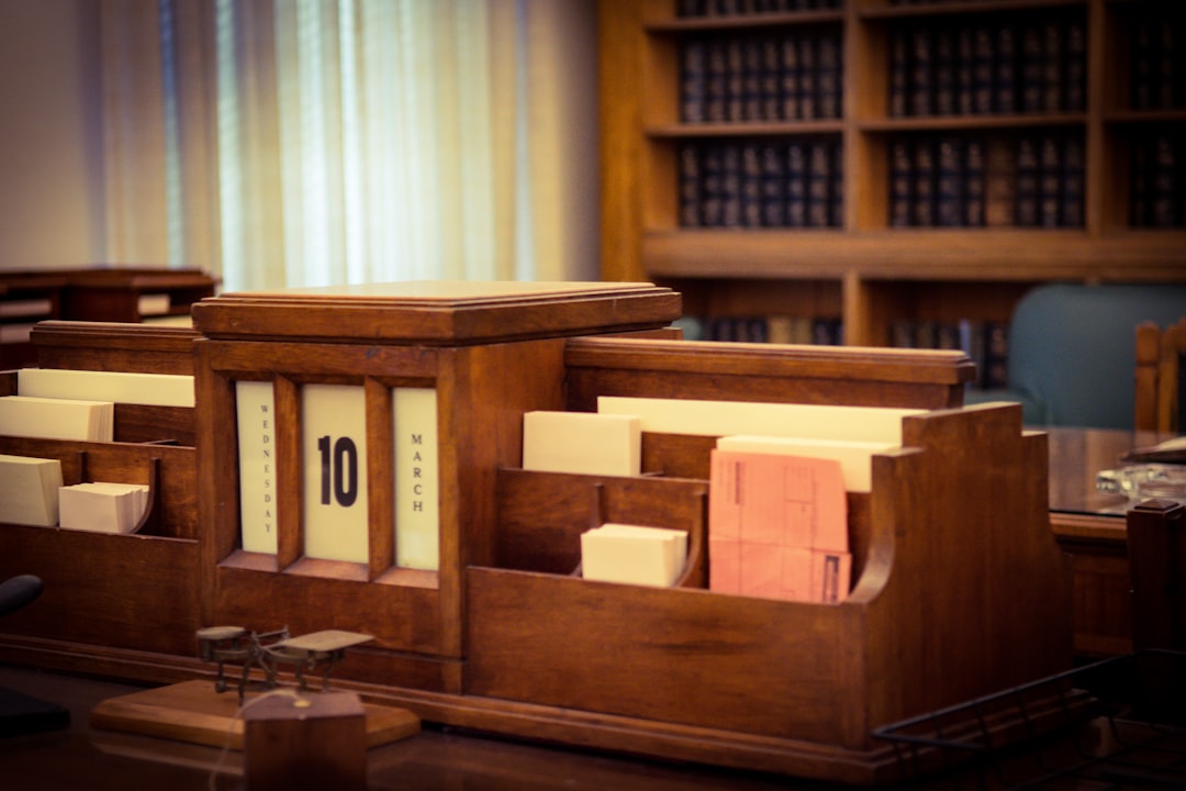 Minimalist courtroom of the future with judge's bench illuminated by soft ambient light, holographic scales of justice balanced against neural network visualization, human lawyer and AI interface in c