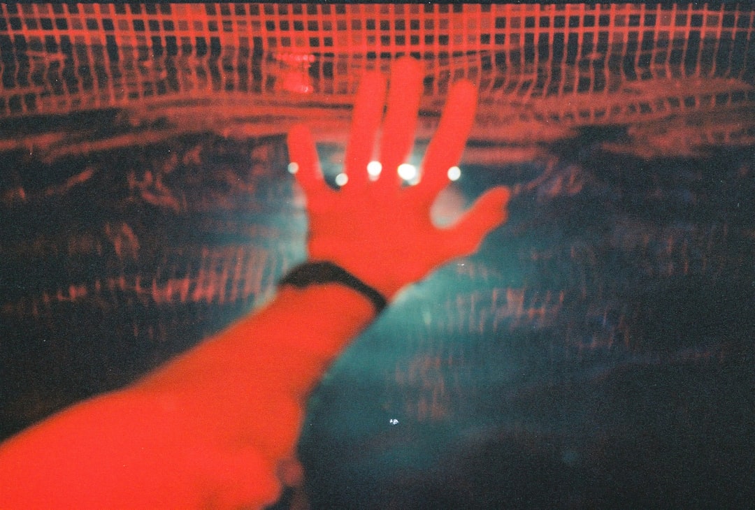 Close-up of human hands reaching toward glowing red warning hologram in dark lab, microchip circuitry visible, dramatic contrast lighting, AI alignment concept