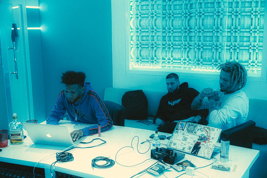 Diverse team of engineers collaborating around holographic sustainable AI model, warm natural lighting through floor-to-ceiling windows, green energy data visualization, sleek modern lab, microchip de