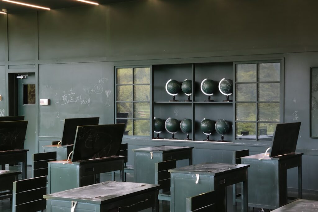 Futuristic classroom with holographic student profiles floating above sleek desks, ambient blue lighting, teacher interacting with transparent AI dashboard, clean modern education technology setting