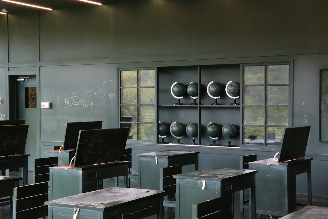 Futuristic classroom with holographic student profiles floating above sleek desks, ambient blue lighting, teacher interacting with transparent AI dashboard, clean modern education technology setting