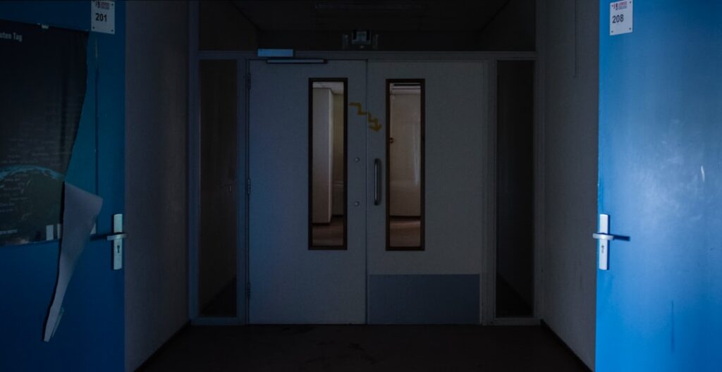 Futuristic hospital corridor with holographic patient data floating above sleek medical tablets, ambient blue lighting, doctor interacting with transparent AI interface, neural network visualization o