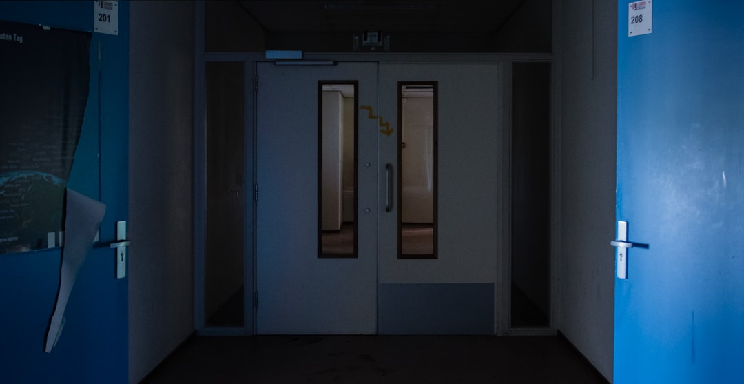 Futuristic hospital corridor with holographic patient data floating above sleek medical tablets, ambient blue lighting, doctor interacting with transparent AI interface, neural network visualization o