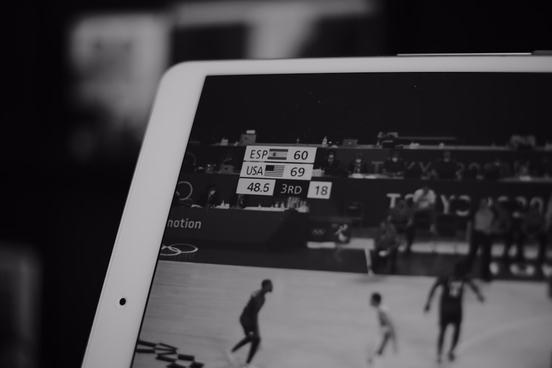 Split screen showing AI neural network and soccer player performance heat map, professional analyst with transparent tablet, futuristic ambient lighting, data particles merging with athletic motion bl